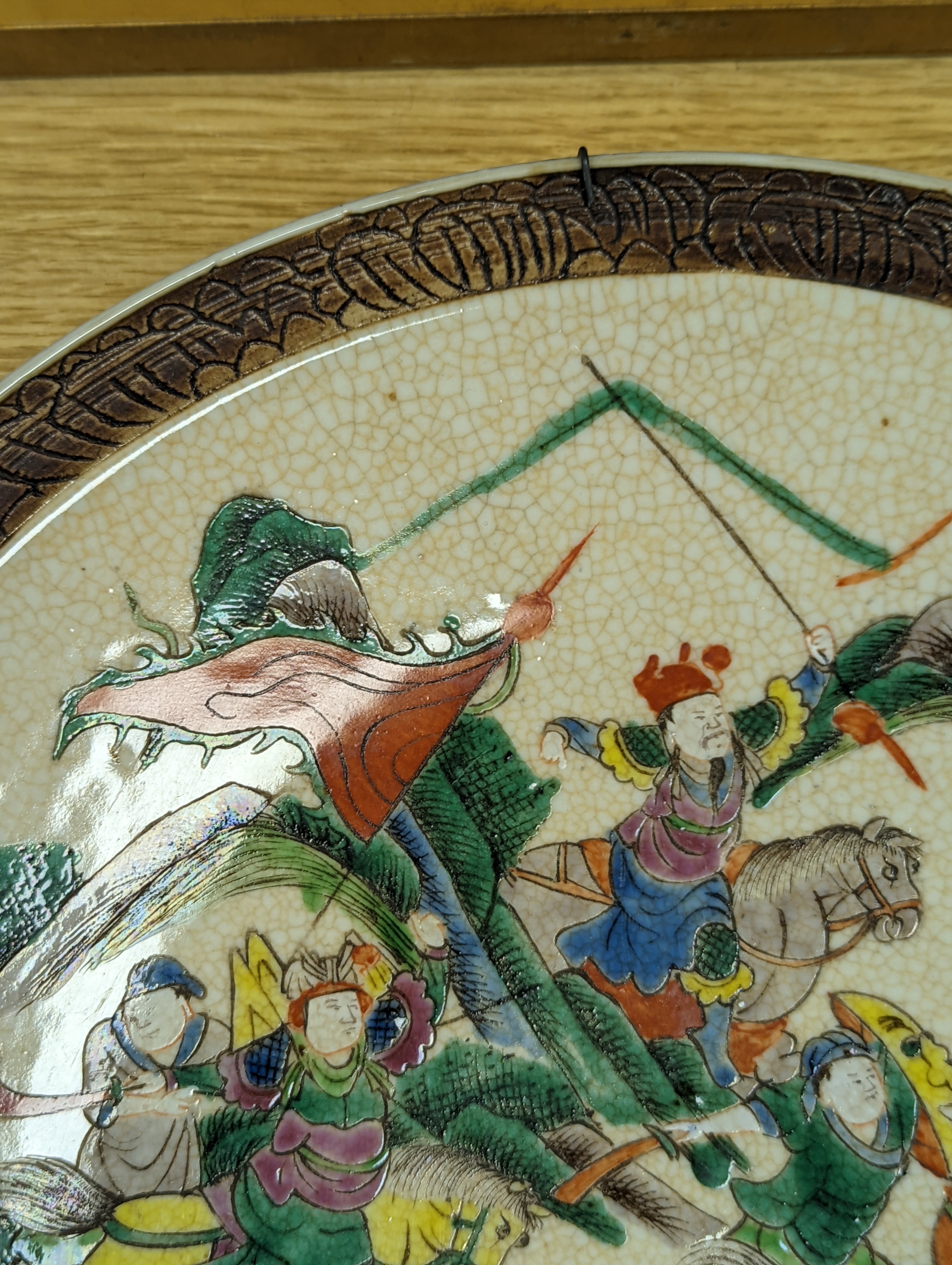 A Chinese crackle glaze dish, early 20th century, depicting a battle scene 33cm